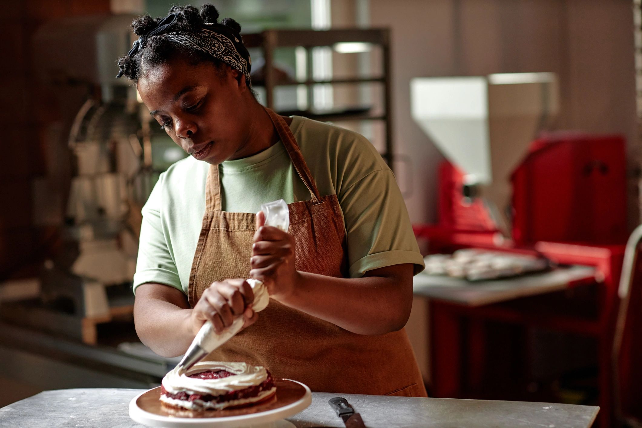 Pastry chef piping icing onto a cake