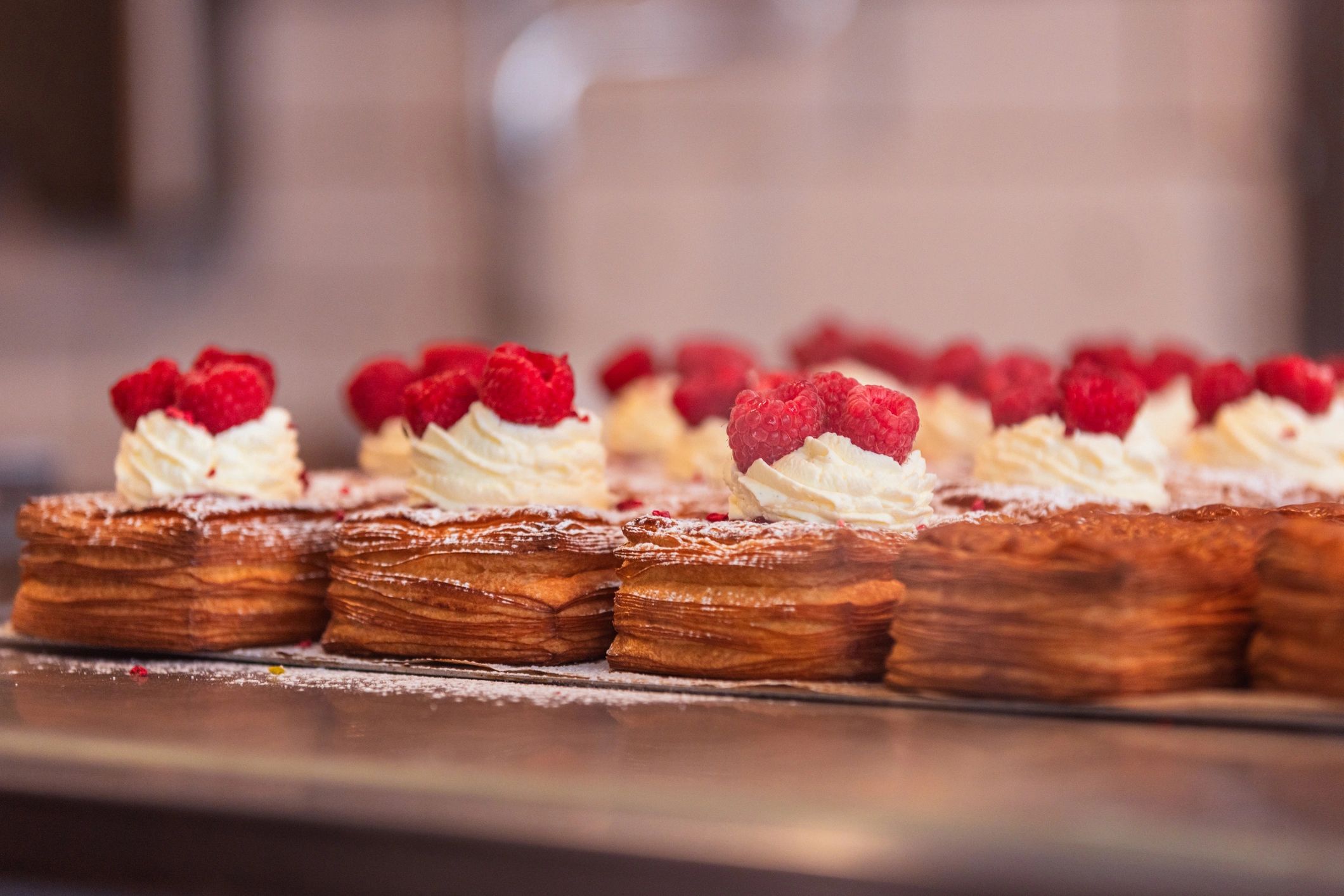 Pastry topped with cream and raspberry