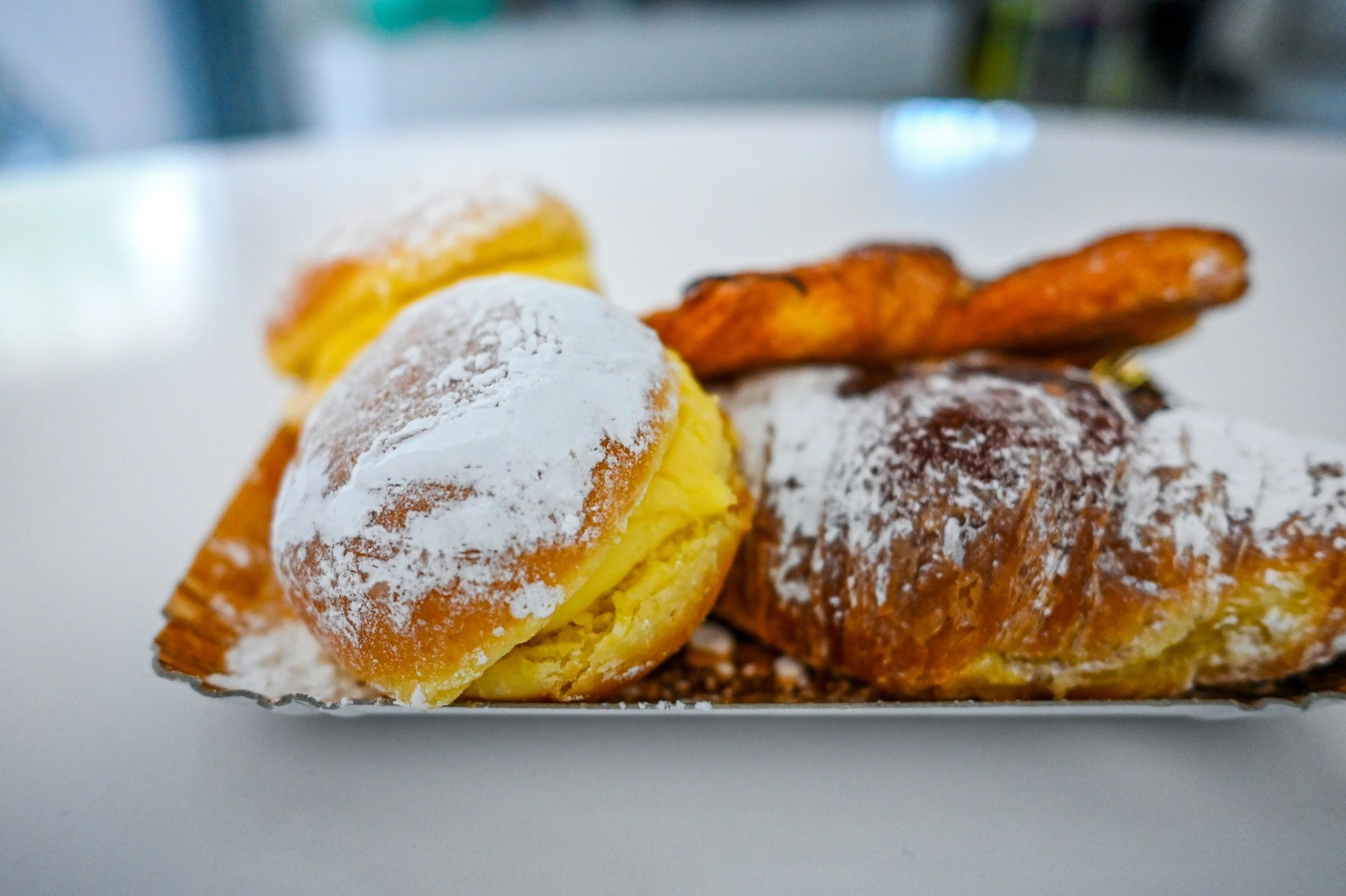 Assorted pastries dusted with powdered sugar on a tray
